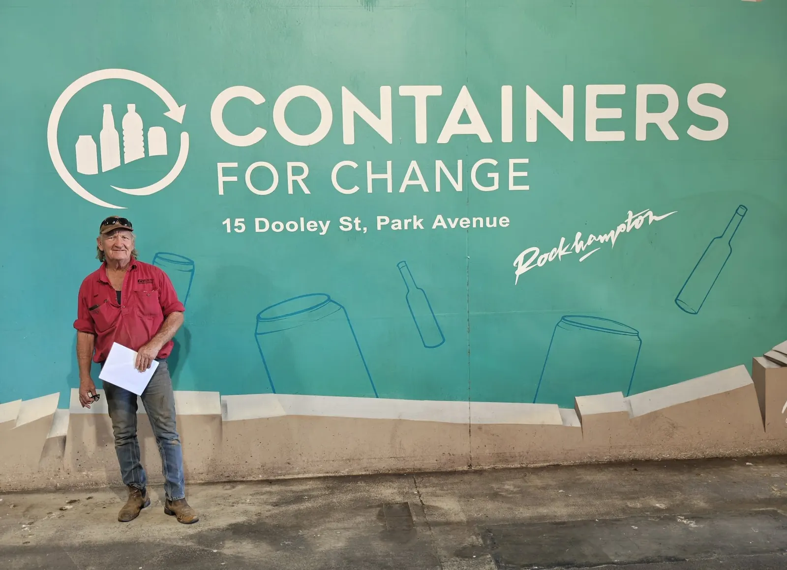 A customer under cover in front of the Containers for Change mural at Park Avenue
